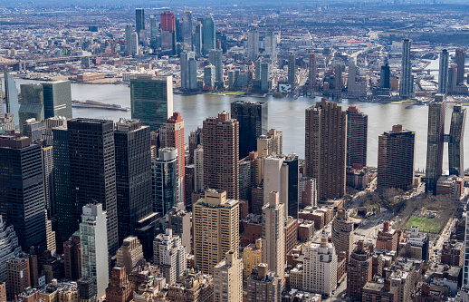 High angle street photography of New York City.  This is on a bright spring day and features the varied roof tops of smaller apartment blocks and buildings.