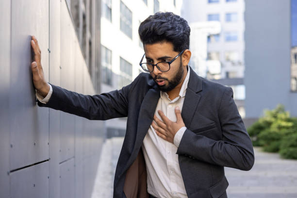 istock Businessman taking a break outside leaning on wall with hand on heart 2148273273