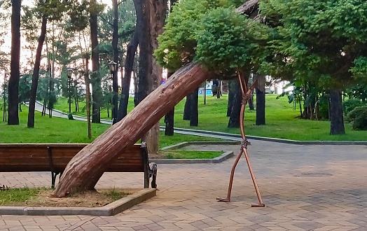 a falling tree is supported by a structure in the shape of a man