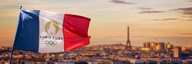 パリ 2024 年夏季オリンピックのロゴが描かれたフランスの国旗、パリのエッフェル塔フランスのパノラマの背景 ストックフォト