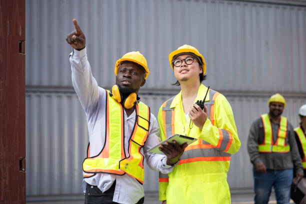 istock Portrait Asia logistic engineer man worker or foreman use walkie talkie working with African American foreman at container site 2148278632
