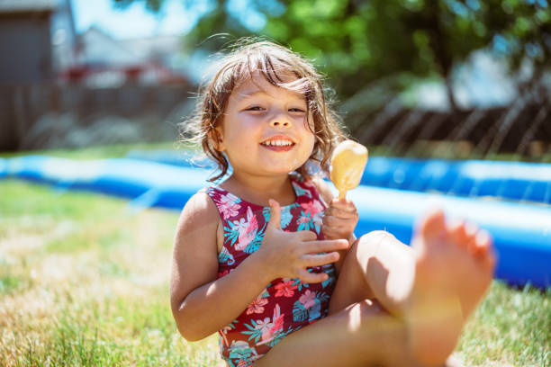 istock Girl smiles while eating a popsicle in her backyard 2148278890