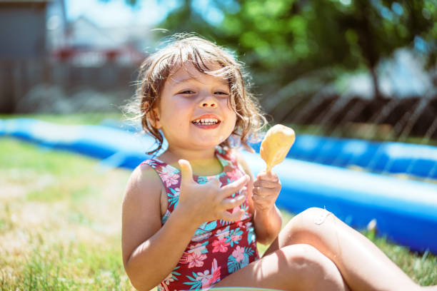 istock Girl smiles while eating a popsicle in her backyard 2148278892