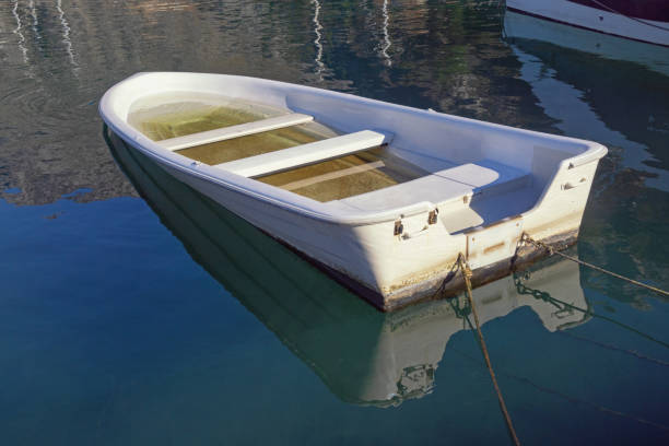 istock Fishing boat filled with water on  calm water surface 2148279527