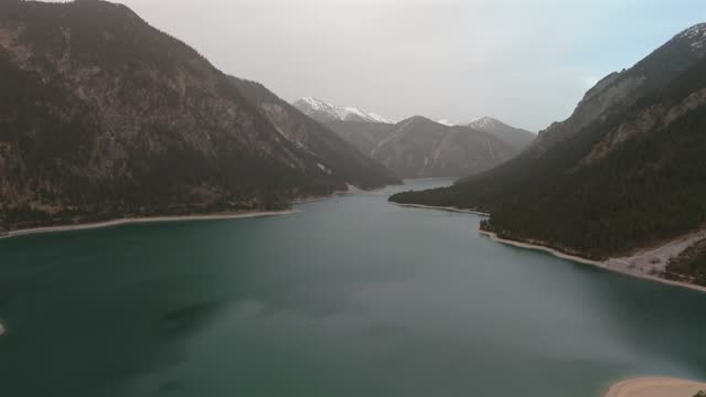 Aerial view Plansee lake in Austrian Alps. See Tirols Plansee. Plansee im Bezirk Reutte, Tirol, Osterreich innerhalb der Ammergauer Alpen. Large clear lake in Austria. Reservoir in mountains.