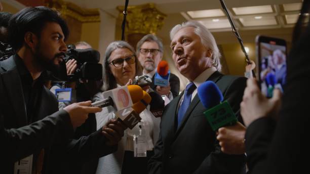 istock Senior diplomat surrounded by crowd of journalists 2148280635