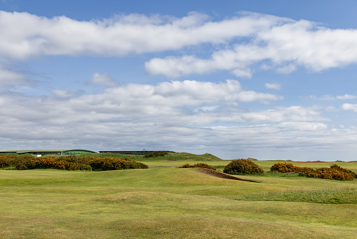 St Andrews - United Kingdom. May 27, 2023: View of The Old Course at St. Andrews golf field, where the natural undulations and vibrant gorse bushes stand against the expansive sky