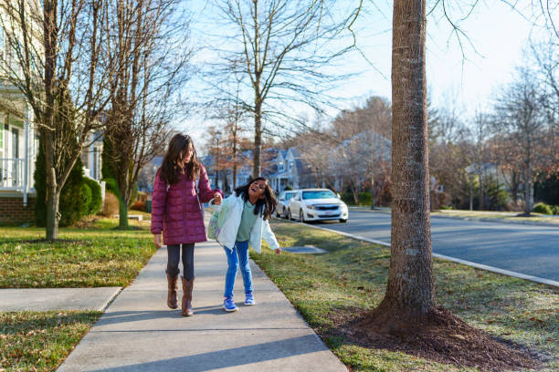 istock Cheerful elementary age girls walking to school bus stop 2148281199