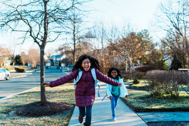 istock Cute girls run down neighborhood sidewalk 2148281210