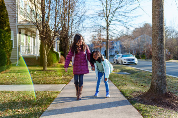 istock Cheerful elementary age girls walking to school bus stop 2148281222