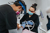 Two dentists provide check up on male patient
