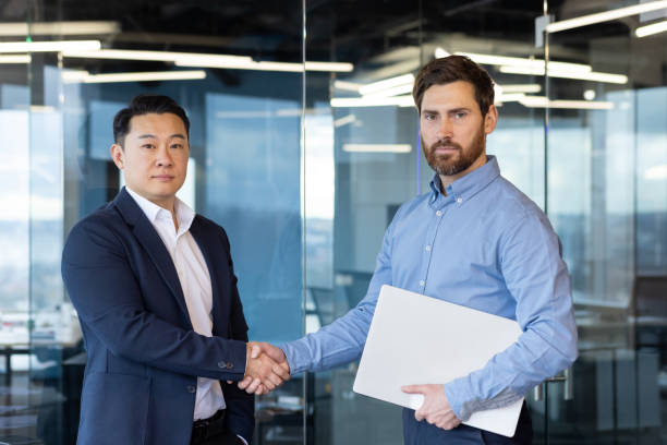 istock Multicultural businessmen handshaking in modern office setting agreement 2148281420