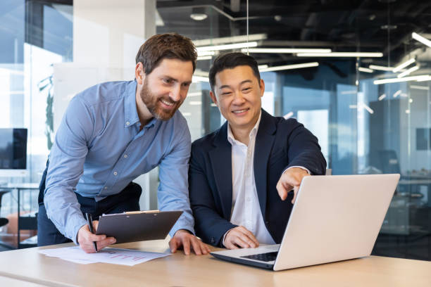 istock Professional businessmen collaborating in an office environment using laptop 2148282074