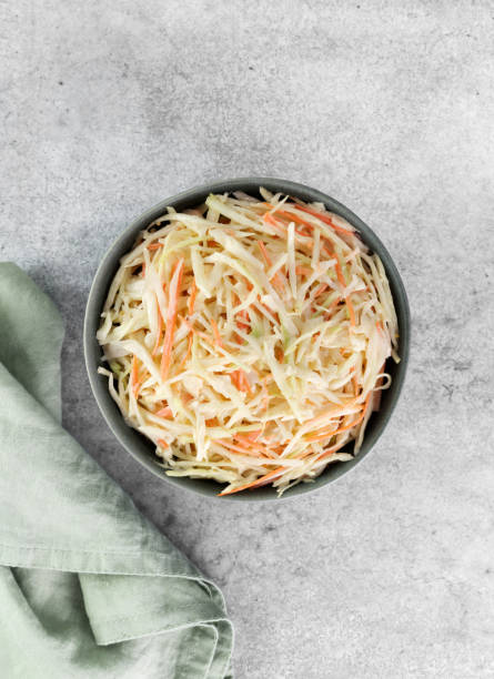 istock Classic coleslaw salad made with fresh cabbage, carrots and dressing on a gray background. American cuisine. Top view 2148283313
