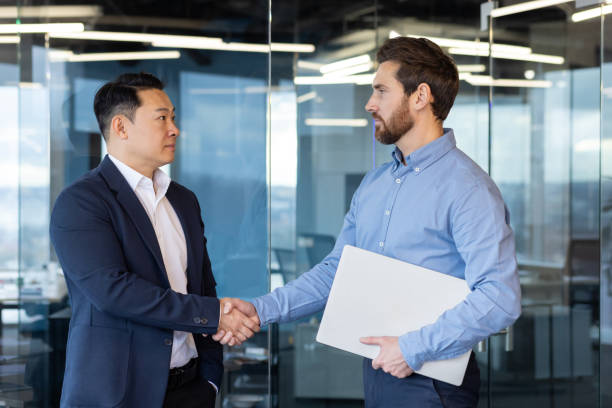 istock Multicultural businessmen shaking hands in modern office, partnership and teamwork concept 2148283884