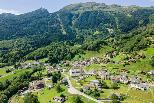 Aerial view of mountain village surrounded by forest, Swiss Alps