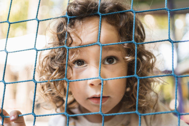 istock Happy little boy playing on a playground outside in natural light 2148284146