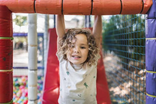 istock Happy little boy playing on a playground outside in natural light 2148284149