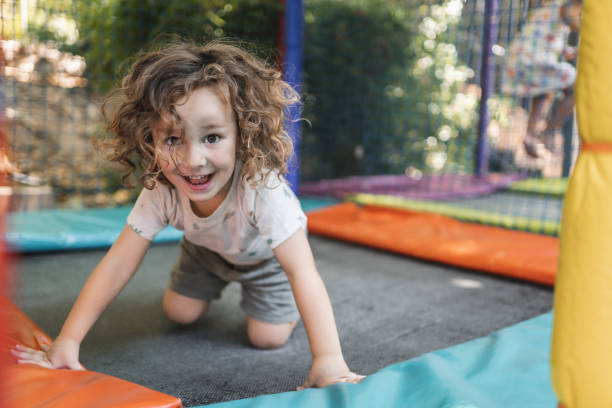 istock Happy little boy playing on a playground outside in natural light 2148284159