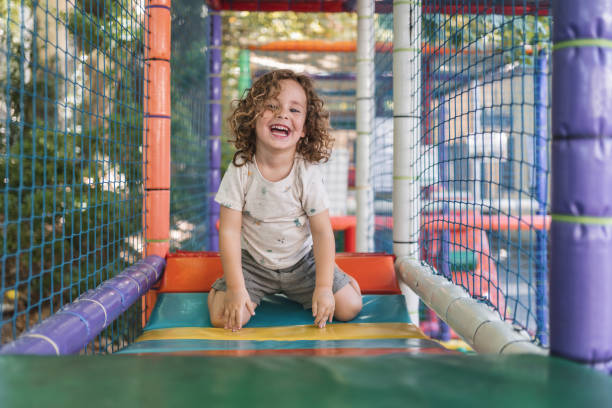 Happy little boy playing on a playground outside in natural light