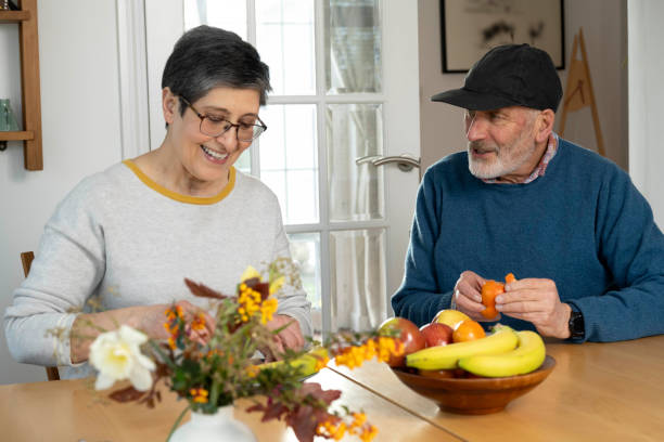 Husband and wife eating fruit, being happy and having a conversation