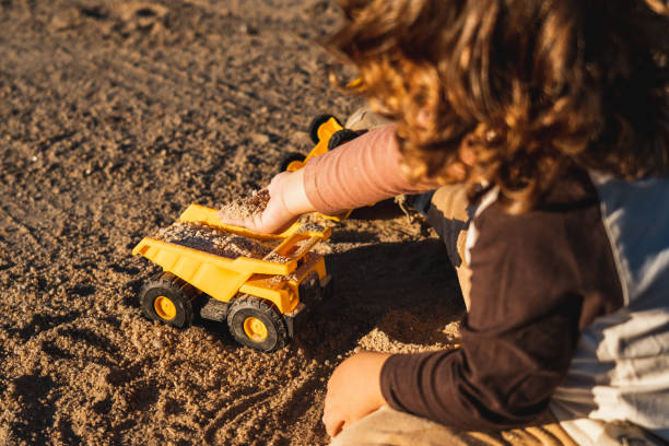 istock Nice happy little boy playing with excavator machine and truck under sunlight 2148285871