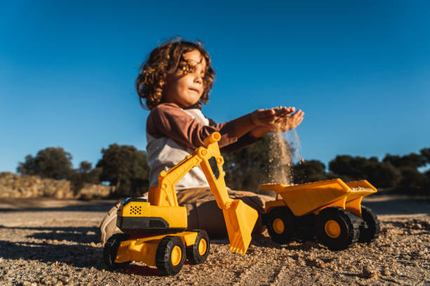 istock Nice happy little boy playing with excavator machine and truck under sunlight 2148285884