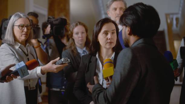 istock Female diplomat surrounded by crowd of journalists 2148286971