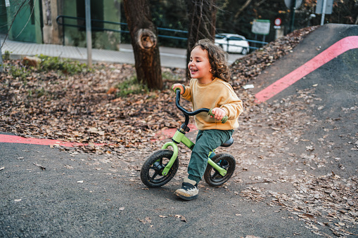 beautiful fashionable boy laughing while training with his bike on urban circuit