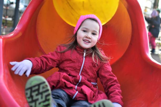 istock little girl rolls down a multi colored slide tube 2148287330