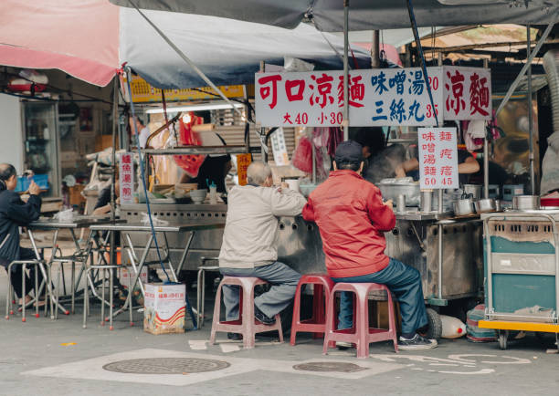 Gaoxiong, Taiwan—Dec 10, 2016: two old men having street food