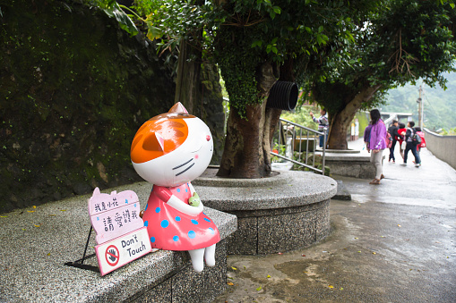 Ruifang, Taiwan—Nov 30, 2016: a cat lady sculpture sitting beside road in Houdong cat village