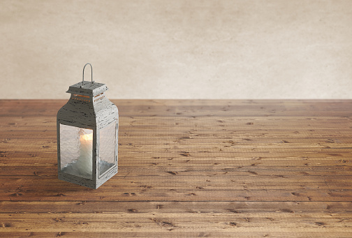 Lantern with candle in it on a wood table background