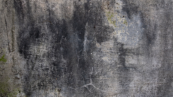 Close up dirty grey concrete wall with black mildew stained background and wallpaper texture