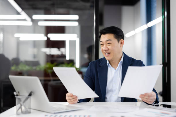 istock Confident businessman reviewing documents at office desk 2148291579