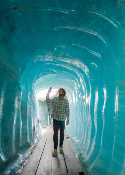 istock Man photographing with smartphone in ice cave 2148292051