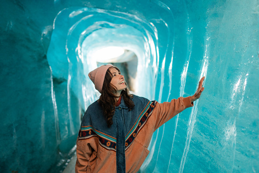 Amazed woman exploring ice cave in Rhone Glacier