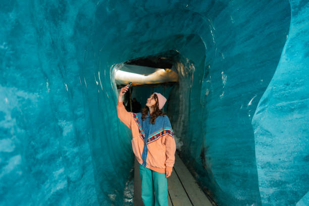 istock Woman photographing with smartphone in ice cave 2148292099