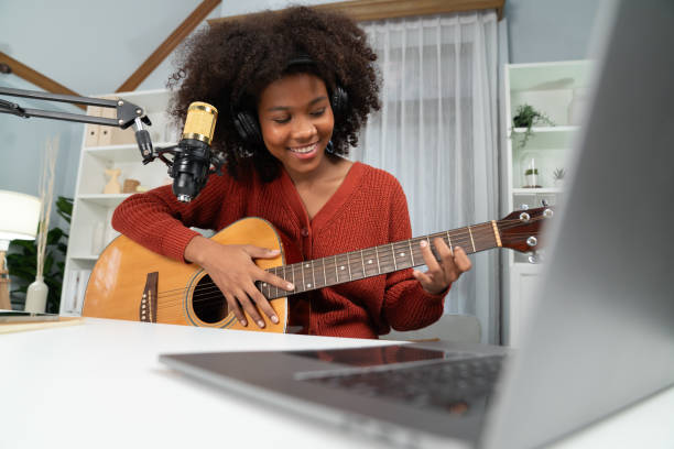 istock American African broadcasting on laptop with playing guitar. Tastemaker. 2148294443