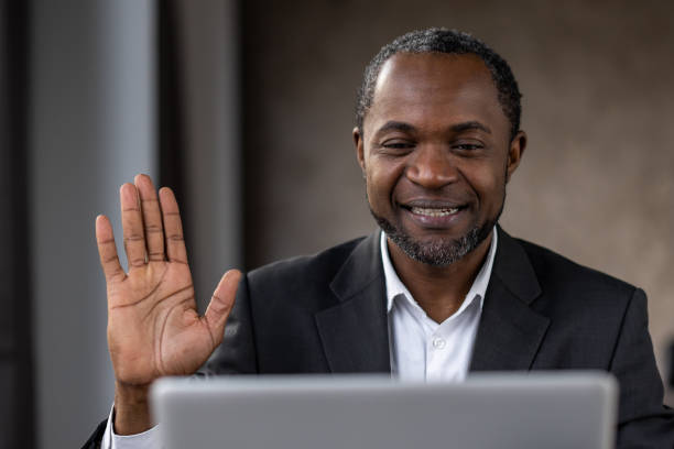 istock A man in a suit is smiling and waving at the camera 2148294657
