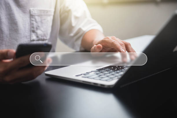 seo search engine optimization. businessman using smartphone with laptop searching browsing internet data information networking from website. - zoekmachine stockfoto's en -beelden