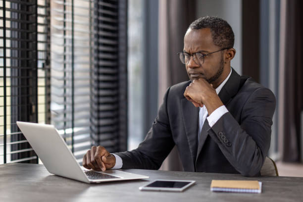 istock Focused businessman working on laptop at office desk 2148295240