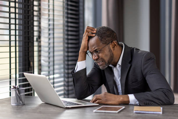 istock Stressed businessman experiencing hardship at work with laptop and smartphone 2148295627