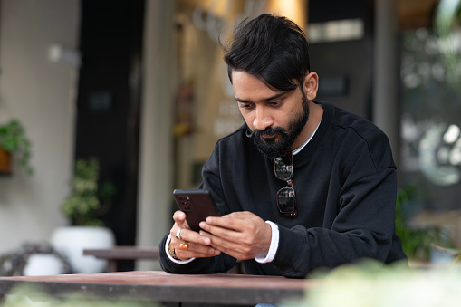 One man use mobile phone while sit at the table at restaurant stock photo