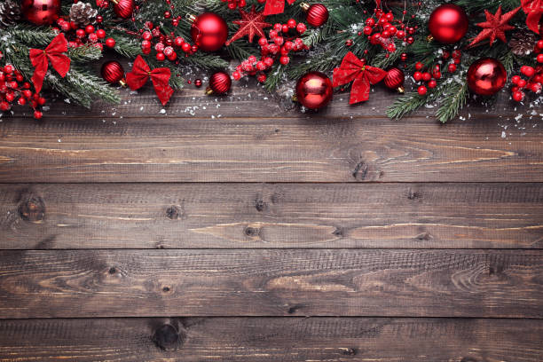 istock Fir tree branches with christmas ornaments on brown wooden table 2148296606