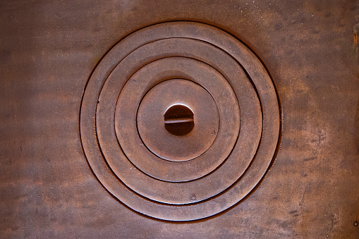 Copper rings on the top plate of an old style wood-fired cooker create an abstract image.