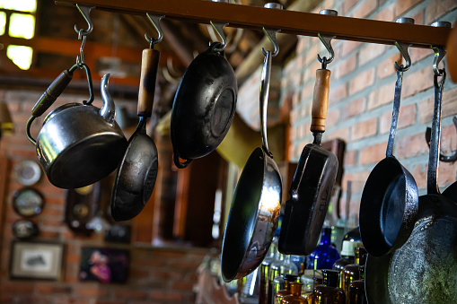 Cooking pans hanging from hooks in a traditional farmhouse kitchen.