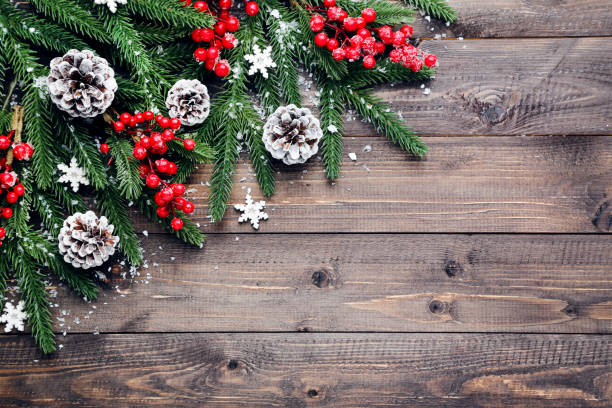 istock Fir tree branches with christmas ornaments on brown wooden table 2148296922