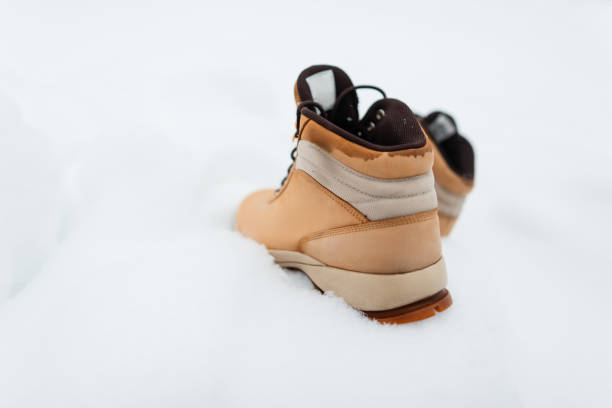 Men's working leather boots on the snow. Beige winter shoes