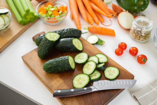 Close up of cutting board filled with fresh organic sliced cucumbers